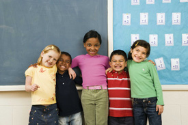 Kids standing in front of chalkboard, smiling